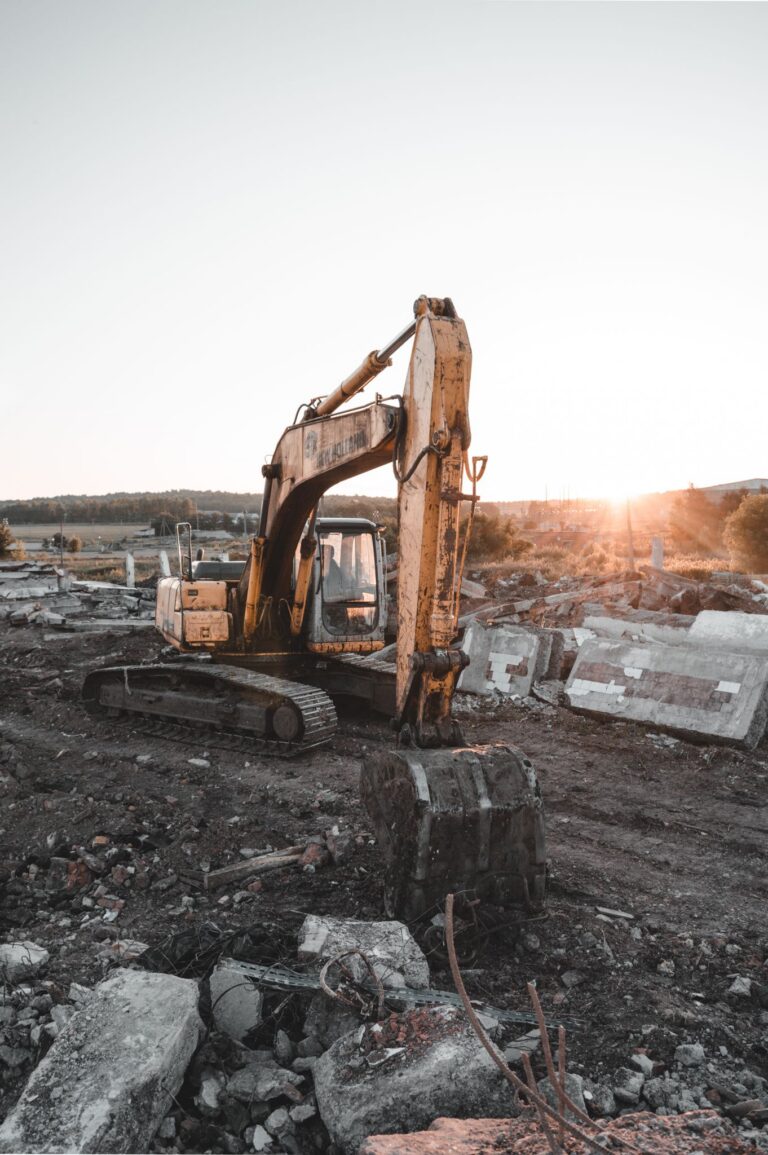 A large excavator at a construction site during a beautiful sunset, showcasing heavy machinery and industrial work.